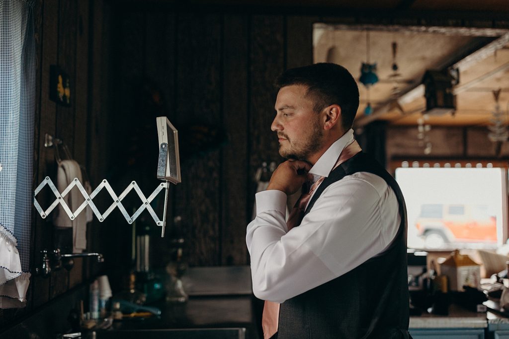 Groom getting ready adjusting his tie