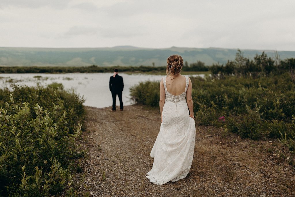 Bride approaching Groom by the lake for First Look