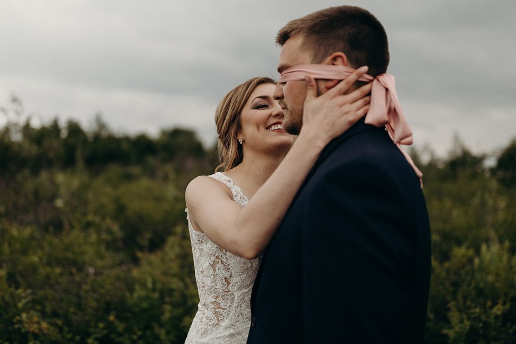 Bride untying blindfold for Groom First Look