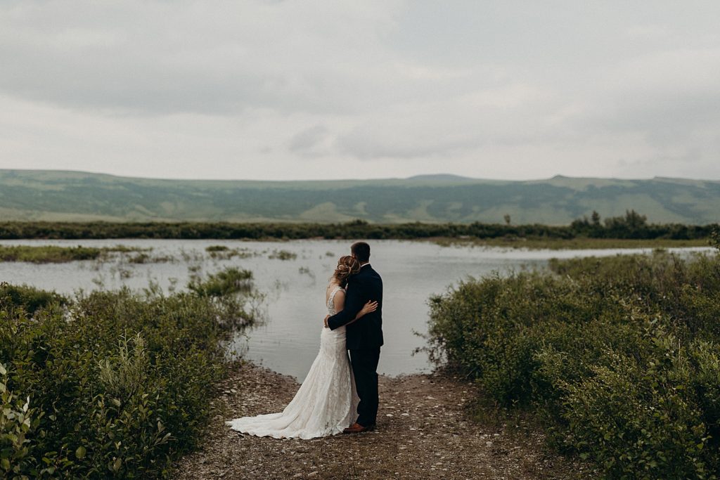 Bride and Groom hugging each other in front of the lake