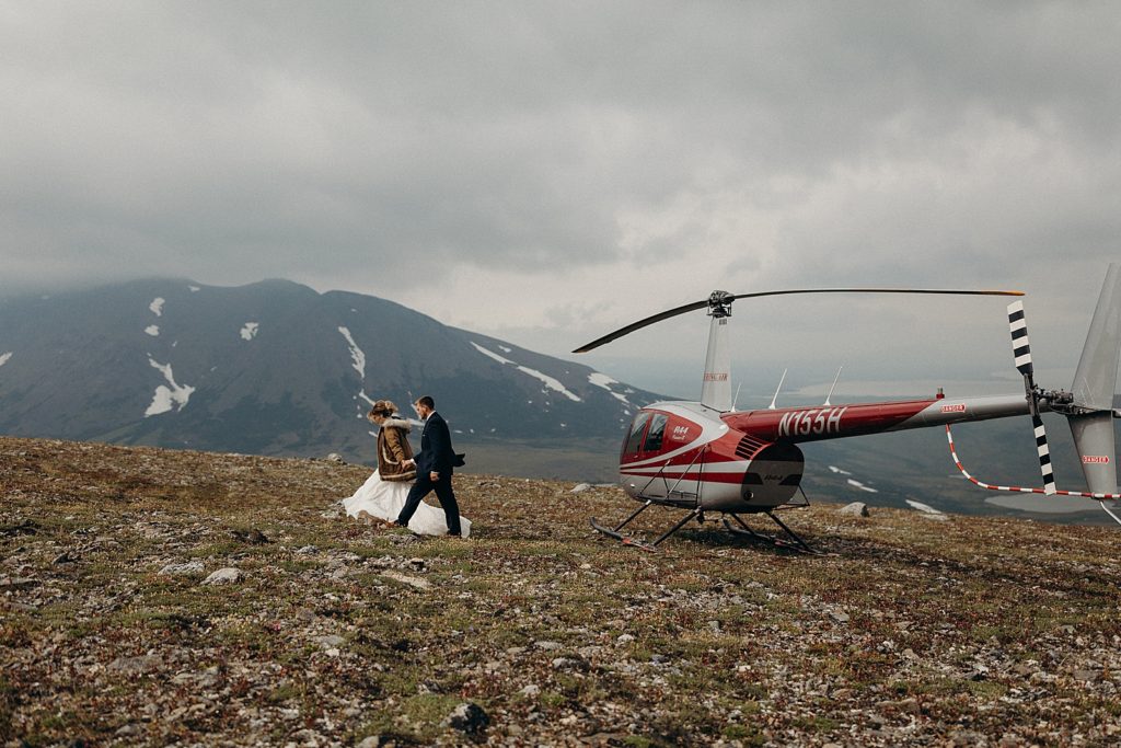 Bride and Groom walking on the mountain by Helicopter