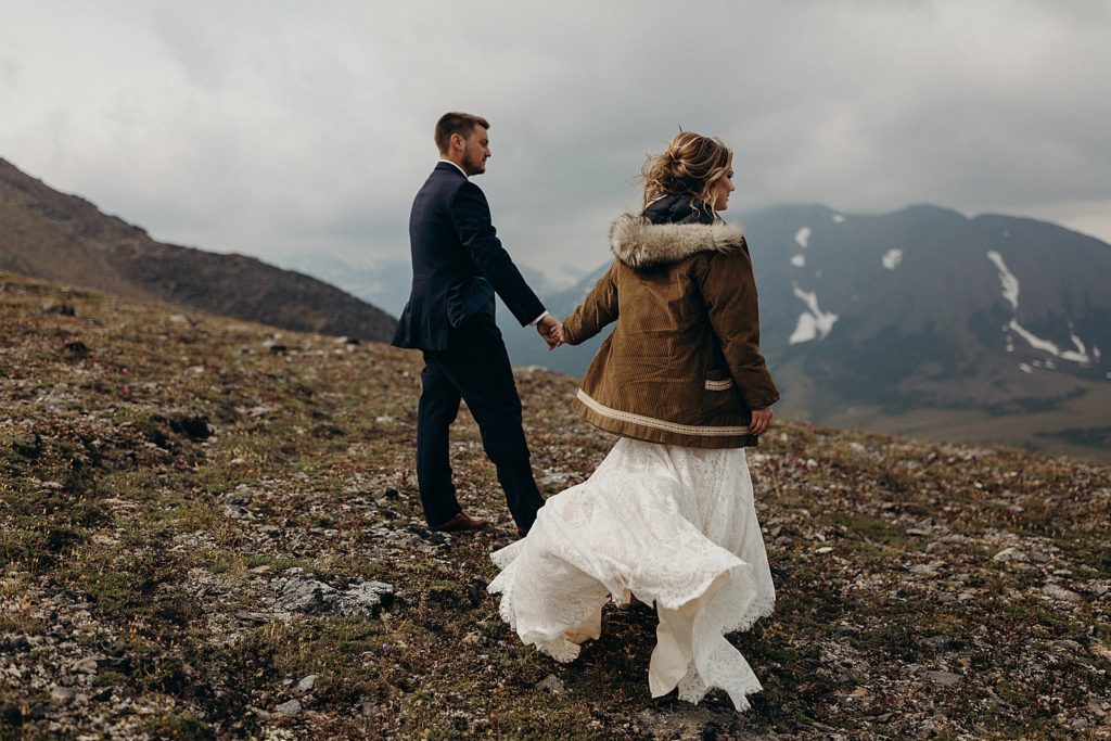 Bride and Groom looking at the mountains and holding hands