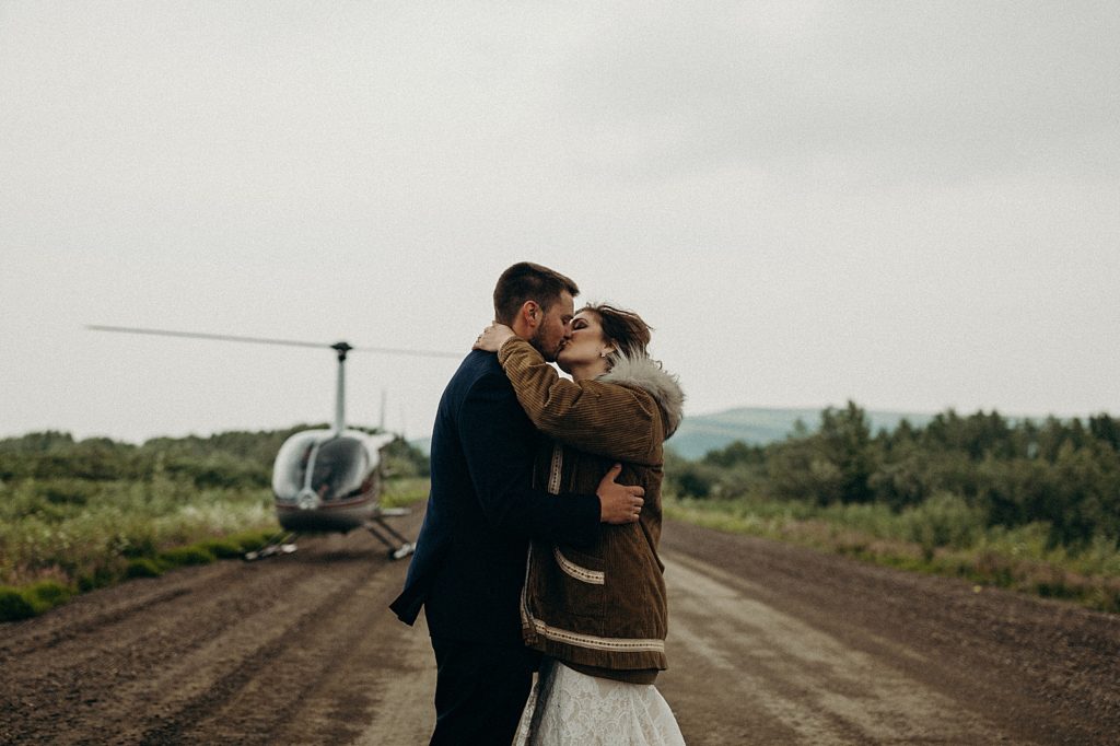 Bride and Groom kissing outside of Helicopter