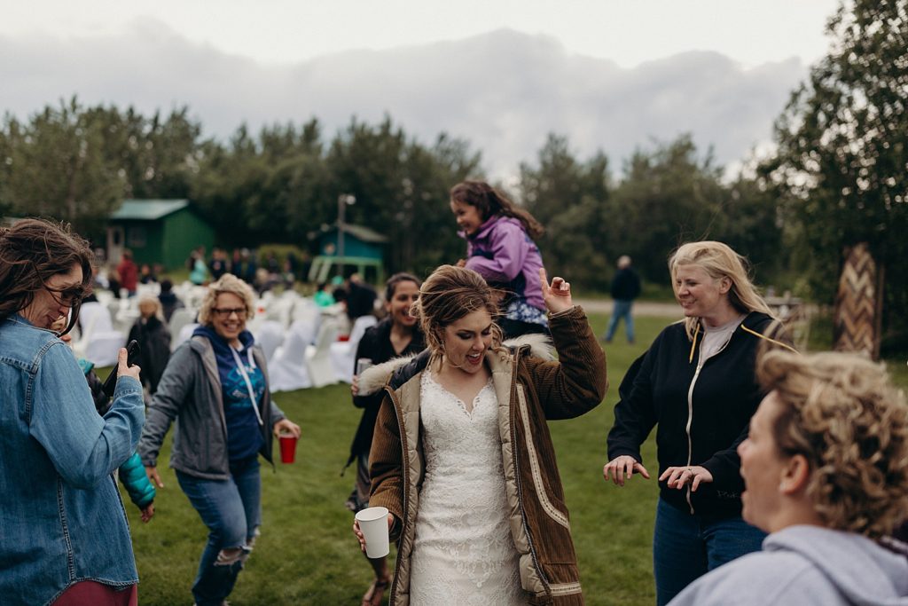 Bride dancing with drink in hand